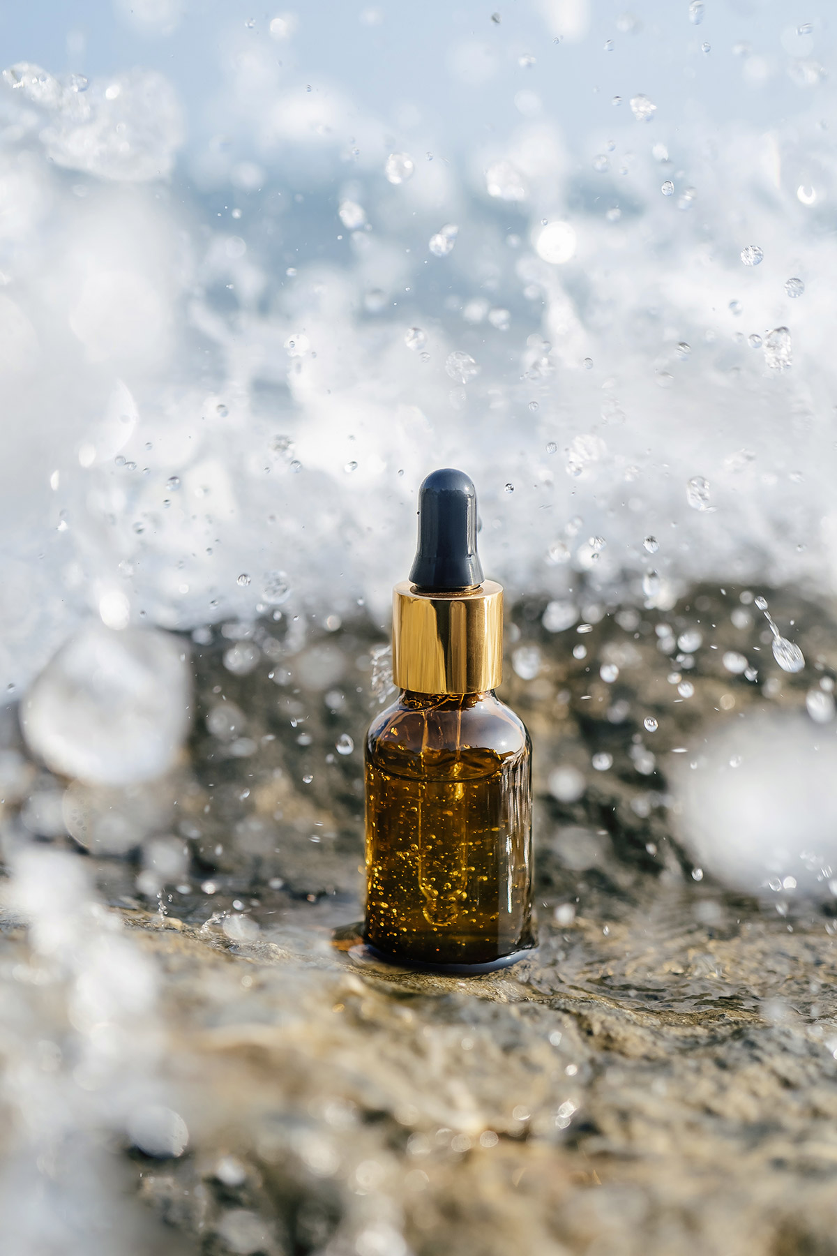 Boccette di profumo su sfondo marino che evocano le fragranze estive